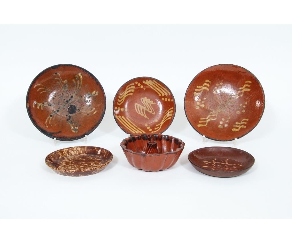 Four redware pie plates with slip 28a686