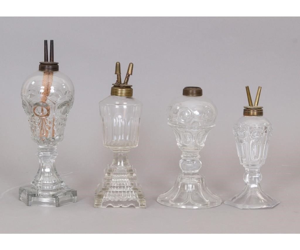 Four clear sandwich glass oil lamps,