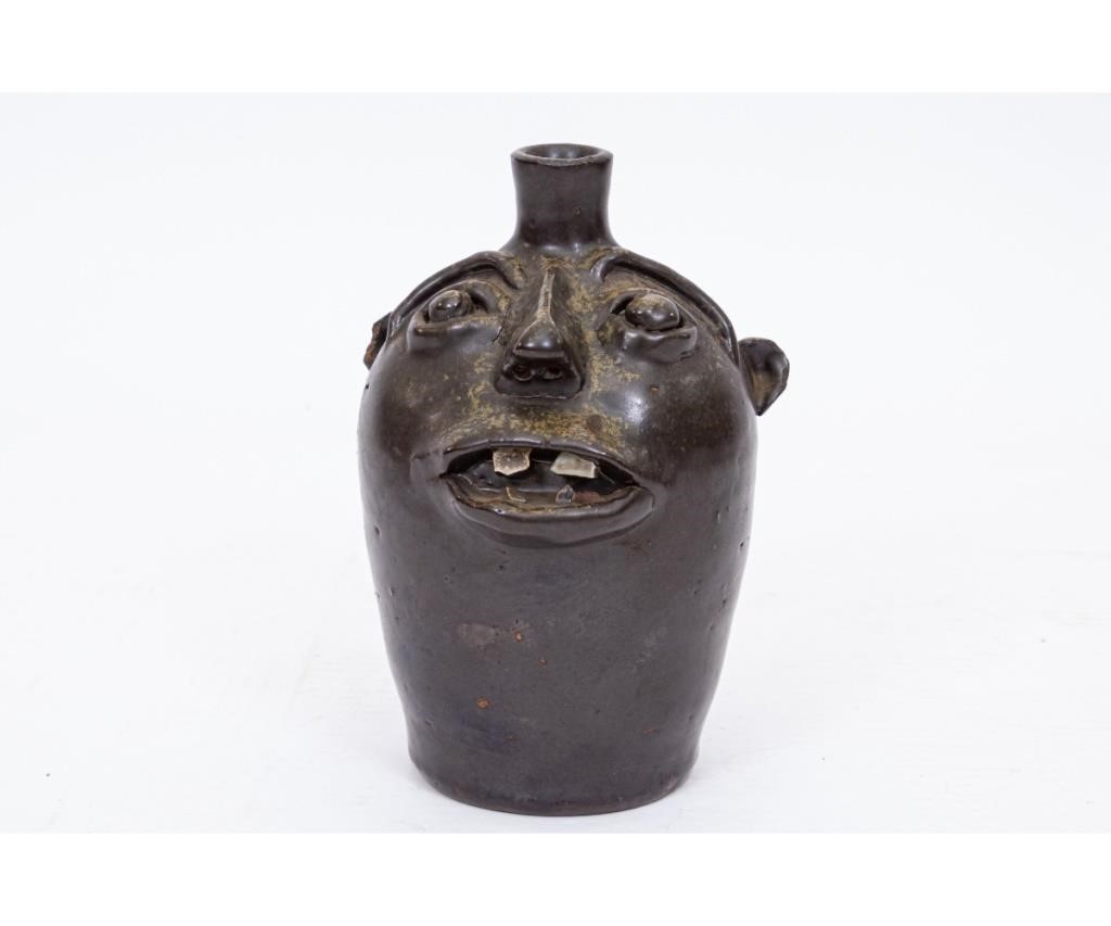 Small redware face jug with dark green
