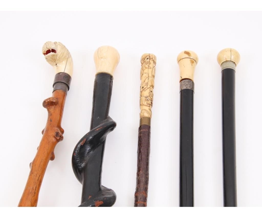 Five carved walking sticks to include