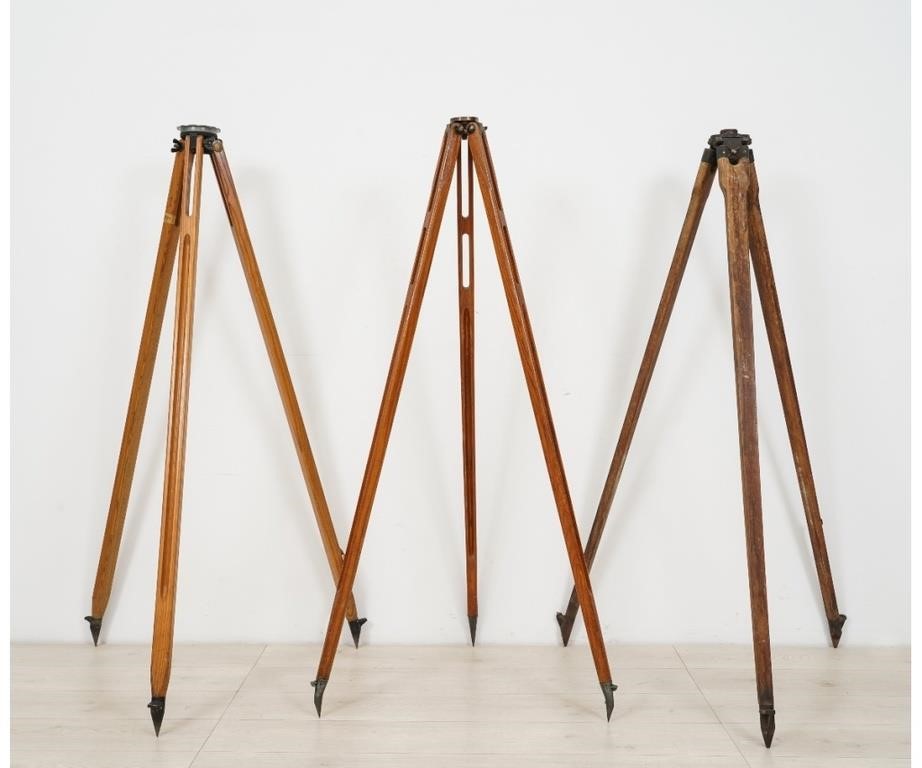 Three wooden transit tripods to