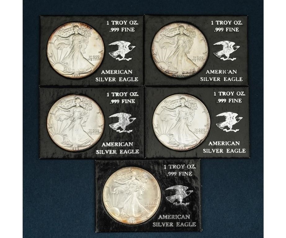 Five American one dollar silver coins,