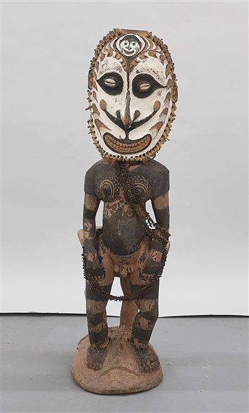 Carved wood standing masked figure from