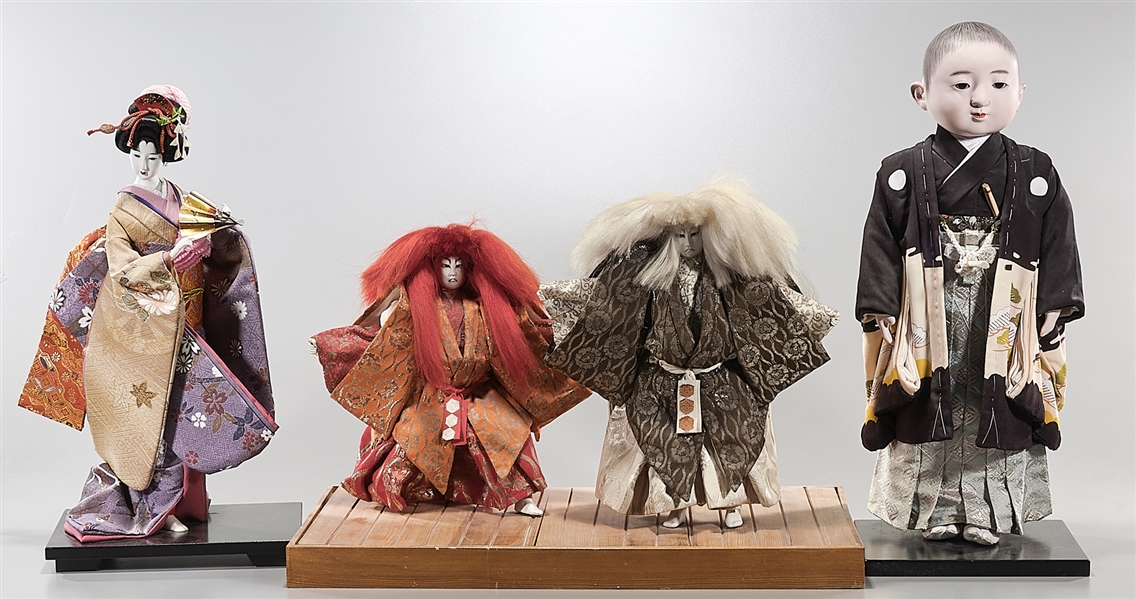 Group of four Japanese dolls with stands;