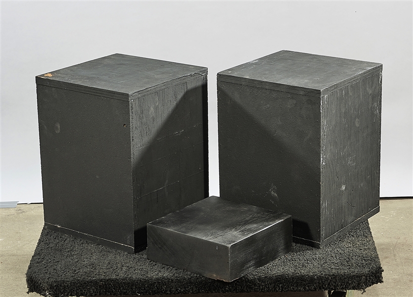Three black wood pedestal stands;