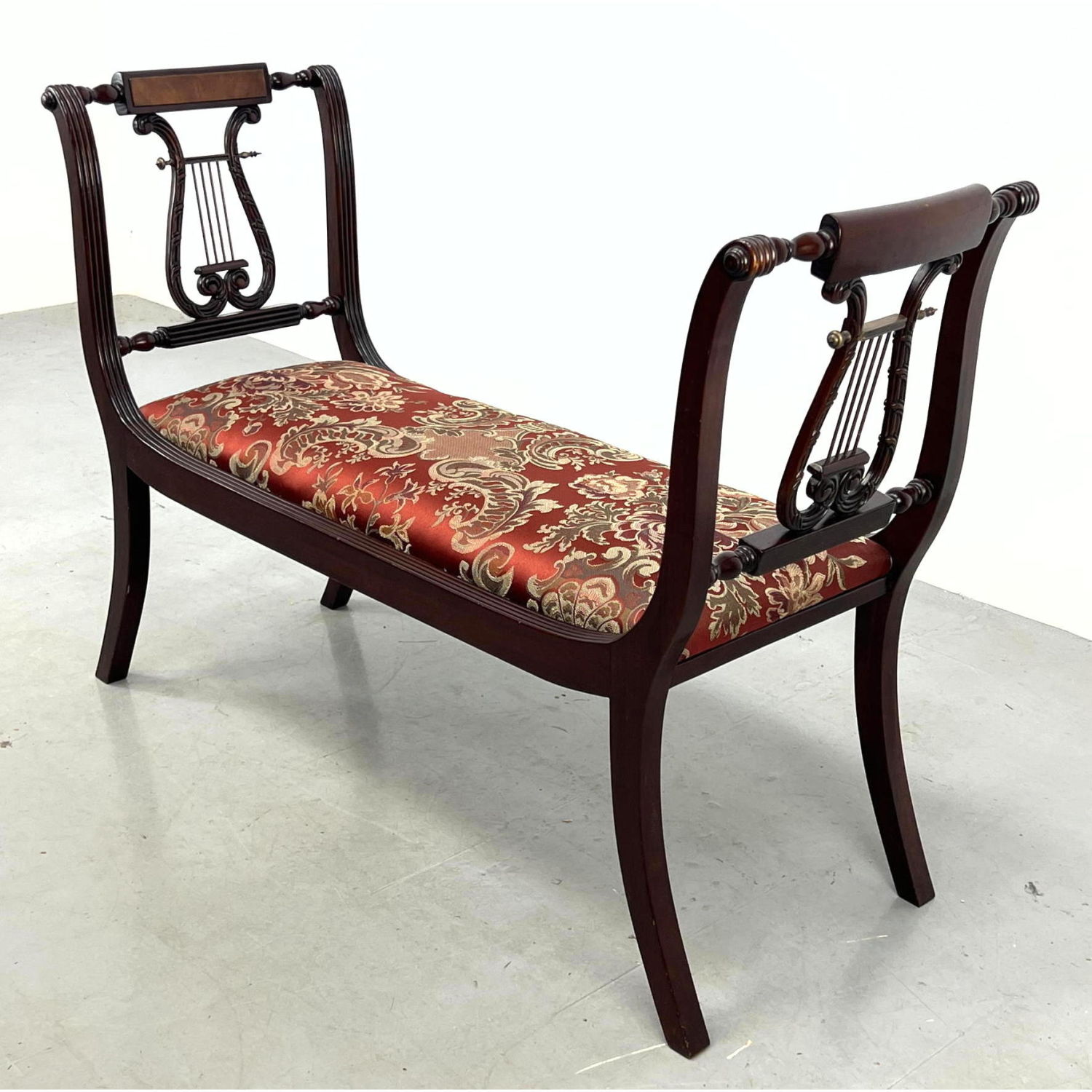 Lyre side mahogany bench with harp decoration.