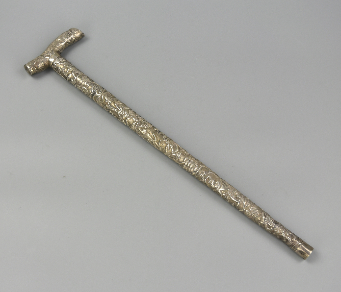 A SMALL ASIAN CARVED SILVER HANDSTICK