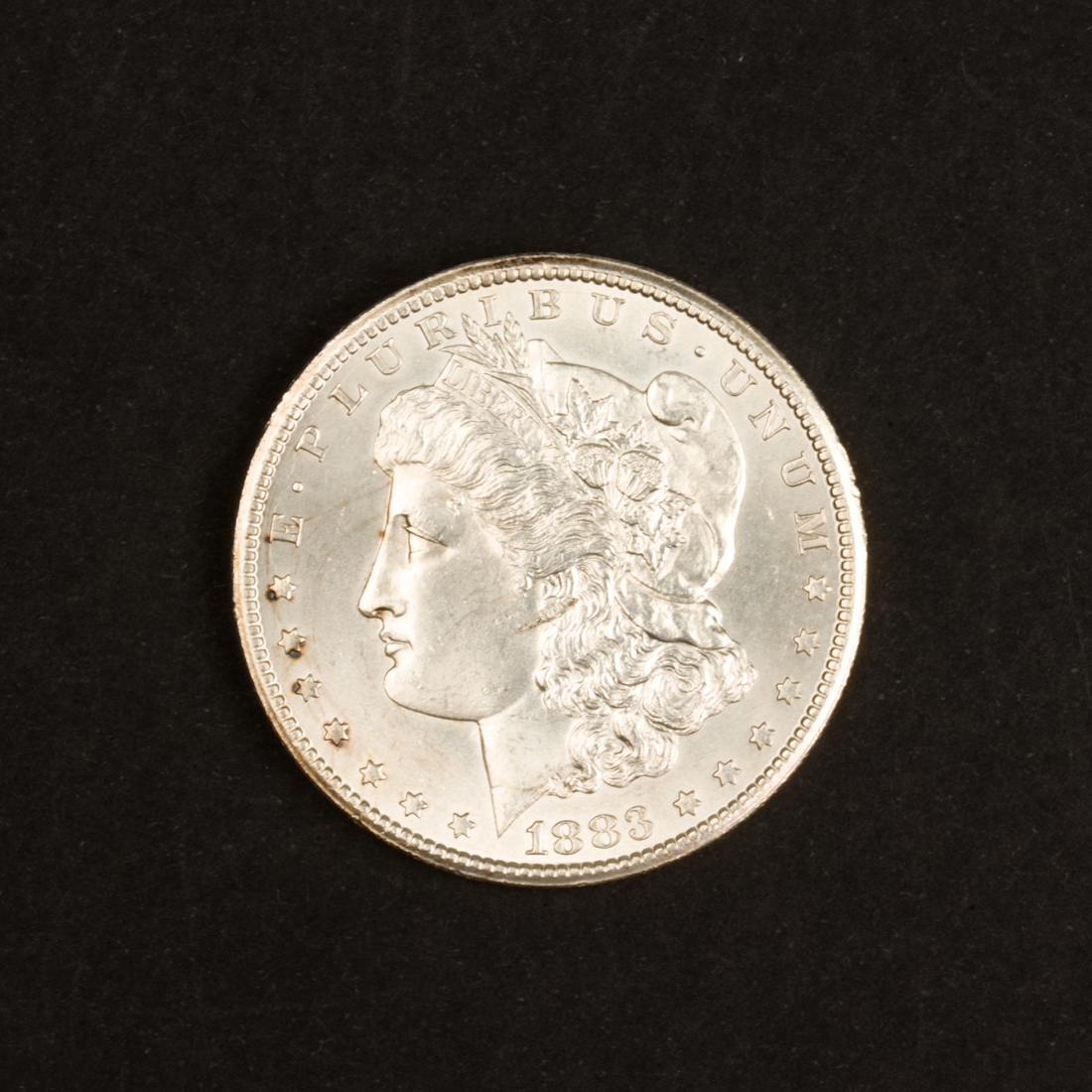 AN 1883CC MORGAN SILVER DOLLAR,