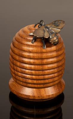 A turned wood thimble box in the