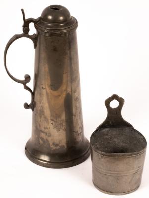 A pewter flagon with scrolled handle