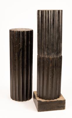 An ebonised plinth of fluted form