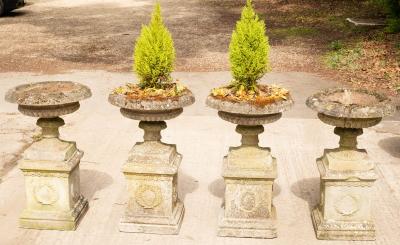 A set of four composition stone urns,