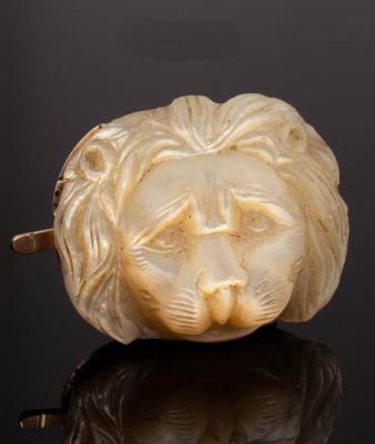 A carved mother-of-pearl lion mask,