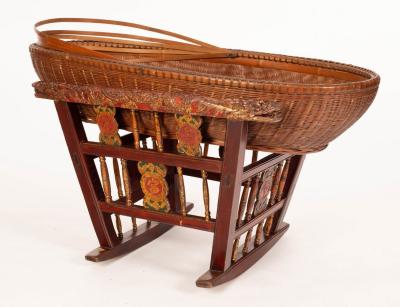 A Chinese basket crib on a carved,