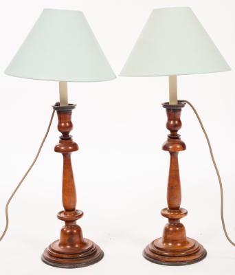 A pair of turned fruitwood candlesticks