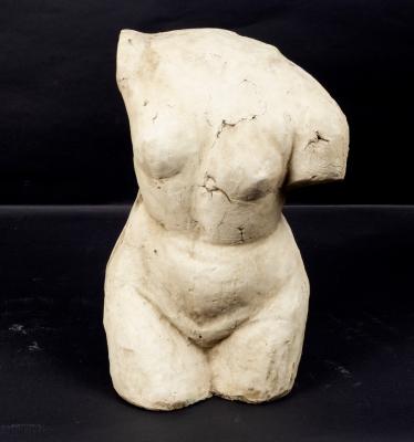A plaster figure of a nude female torso,