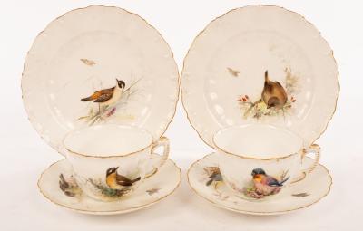 A pair of tea cups and saucers painted