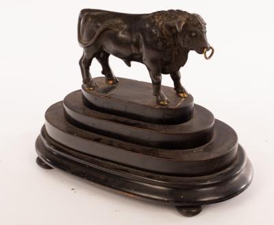 A bronze figure of a bull on a stepped