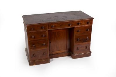 A mahogany kneehole desk fitted a surround