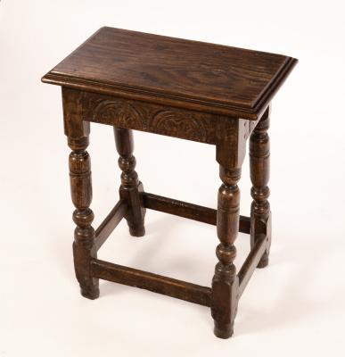 A carved oak joint stool, on baluster