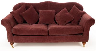 An upholstered sofa covered in mauve