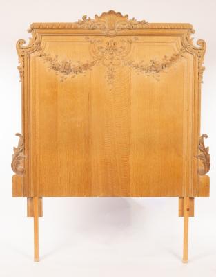 A carved oak headboard, the gadrooned