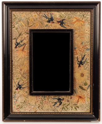 A needlework framed wall mirror,