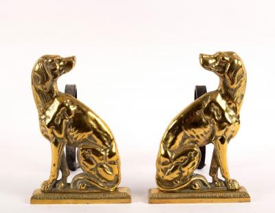 A pair of brass fire dogs, each modelled