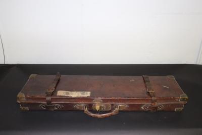 A fitted leather gun case with some