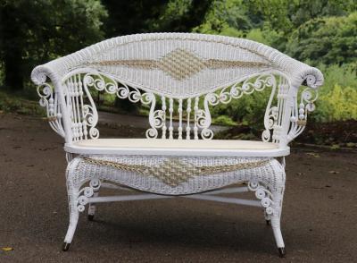 A cane two-seater sofa with scroll arms,