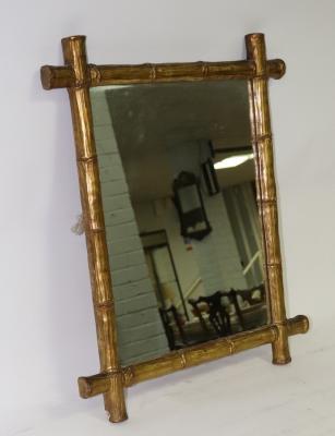 A wall mirror with a gilded simulated