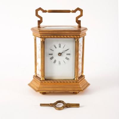 A gilt brass mantle clock set with porcelain