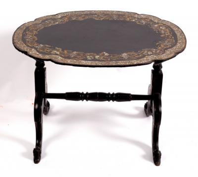 A black japanned trestle table,