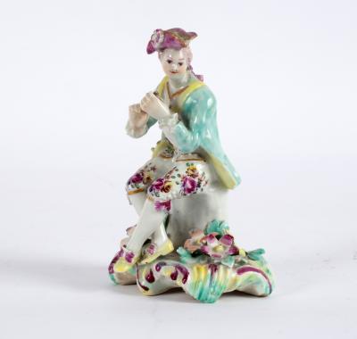 A Derby figure of a seated musician,