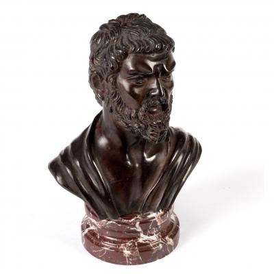 A bronze bust of a bearded man on a
