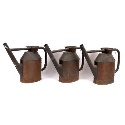 Three copper watering cans, 42cm high