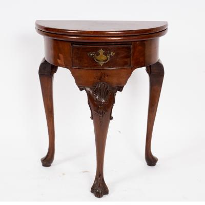 A walnut semi-circular fold-over top