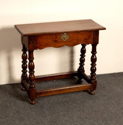 An oak table with shaped frieze on baluster