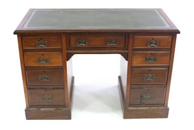 An Edwardian pedestal desk, fitted