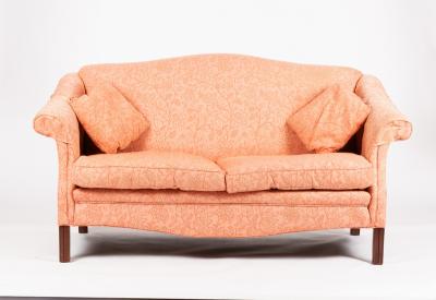 An upholstered sofa with arch back and