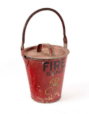 A red fire bucket with lid, marked Fire