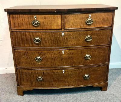 An oak bowfront chest of two short over