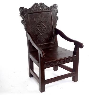 A carved oak panel back armchair
