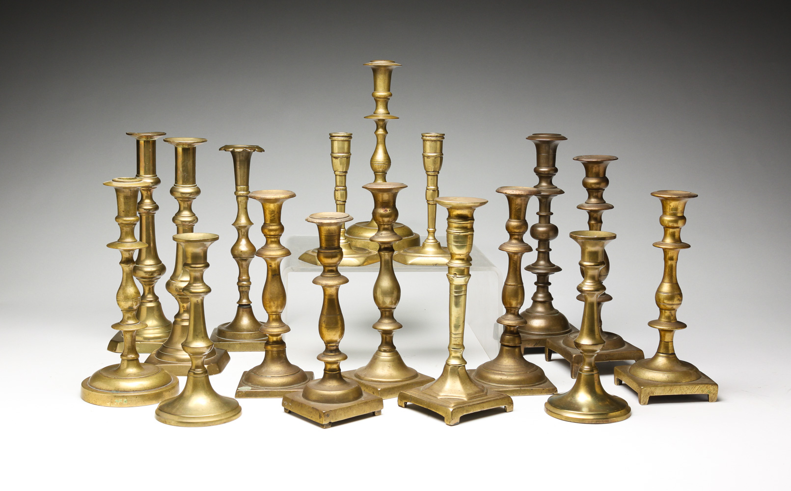 SEVENTEEN EUROPEAN BRASS CANDLESTICKS.