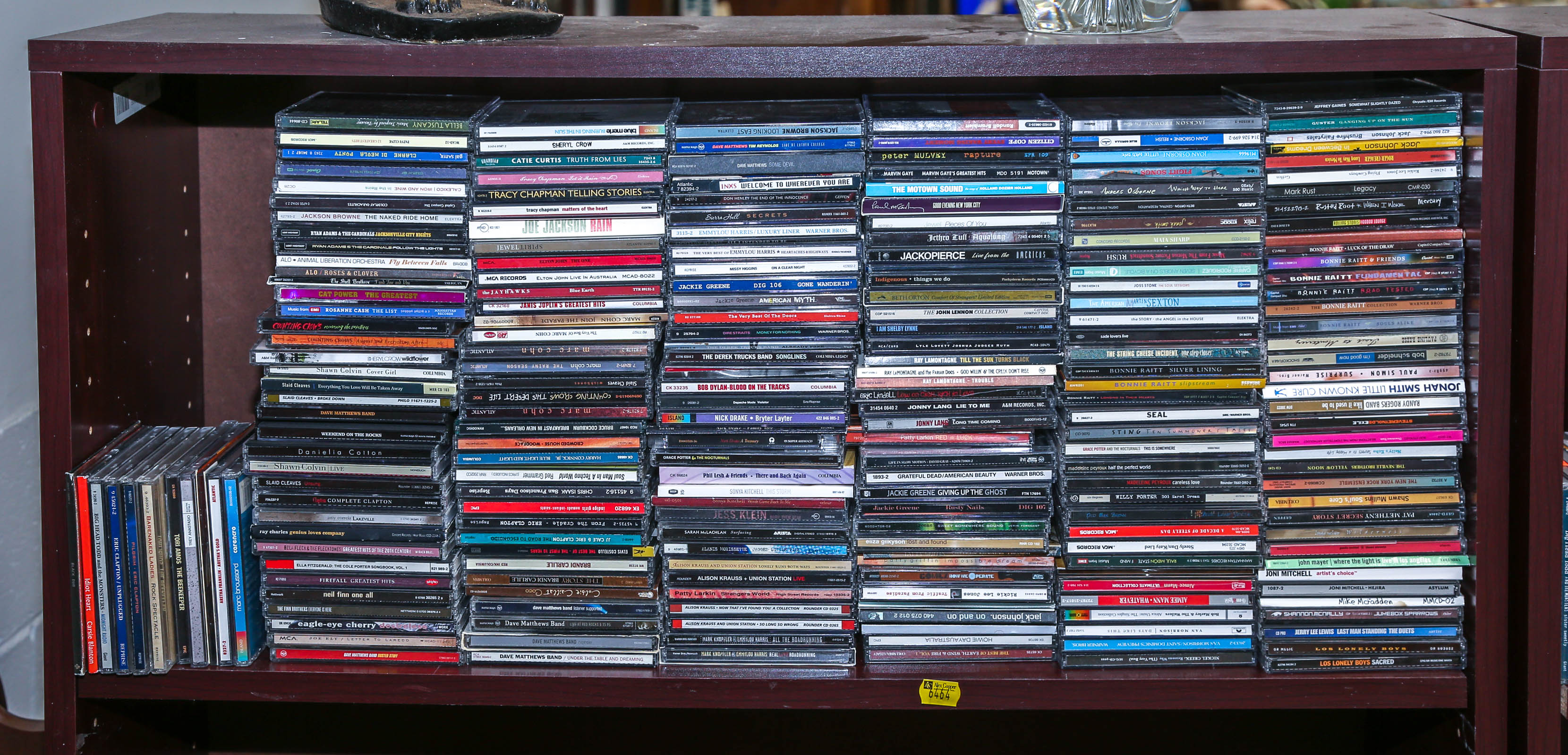 SHELF OF ASSORTED MUSICAL CDS Primarily