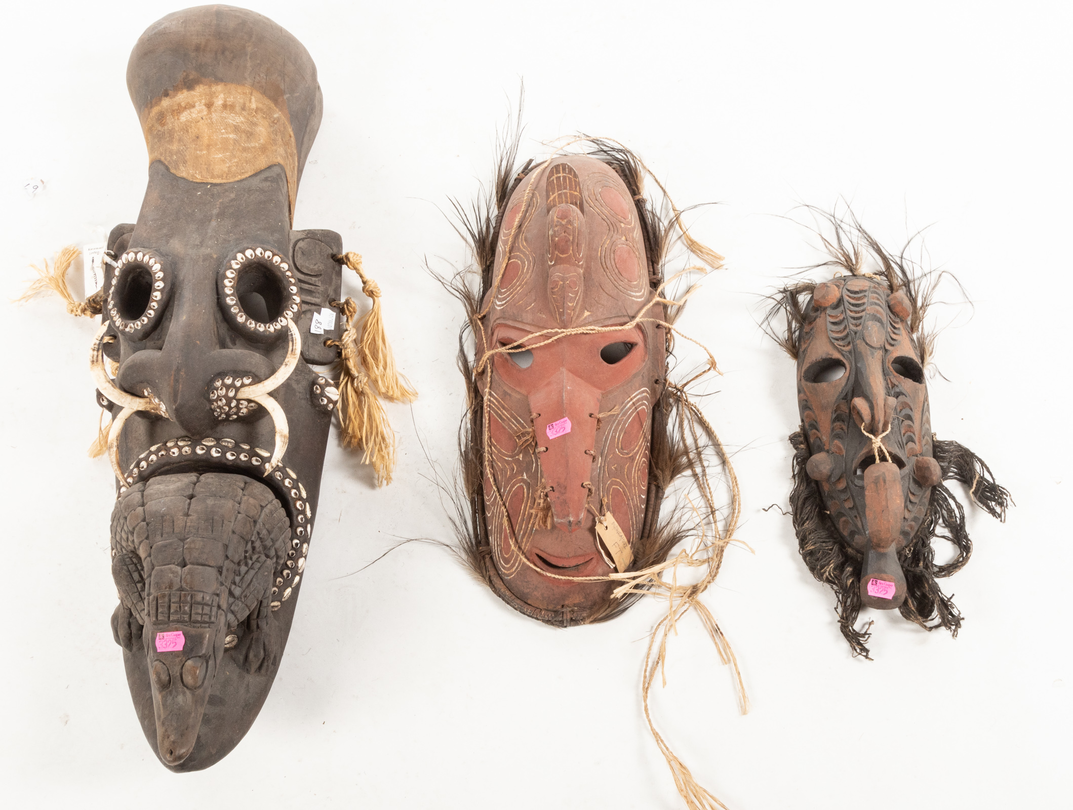 THREE AFRICAN MASKS Carved and