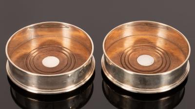 A pair of modern silver wine coasters,