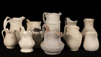 Eleven saltware jugs, various patterns,