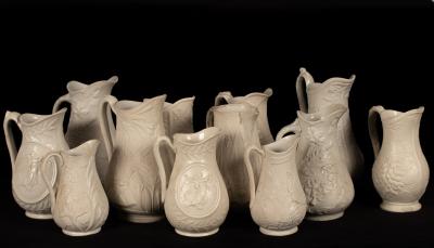 Twelve saltware jugs, floral decoration