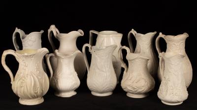 Ten saltware jugs, most with floral